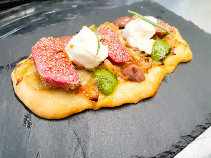 "Coca" di fichi e cipolle caramellate con ricotta e pesto di basilico