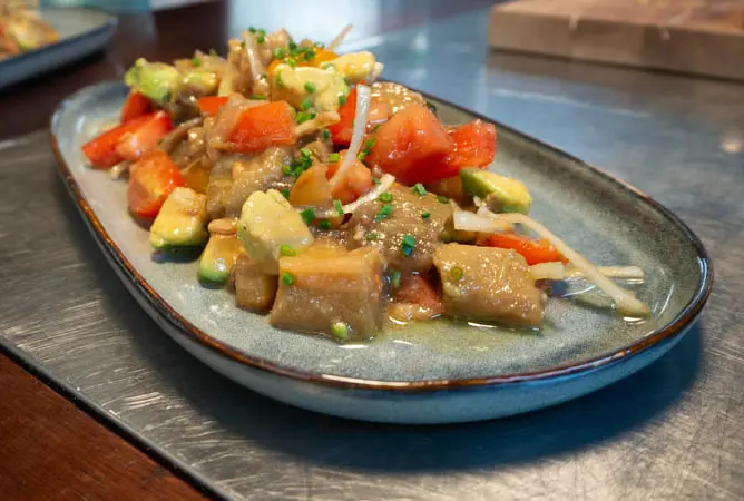 Tomaten-Avocado-Salat mit gerösteter Aubergine und roten Zwiebeln in Soja-Vinaigrette und Sesamöl